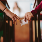 Hands of two students passing a note in class